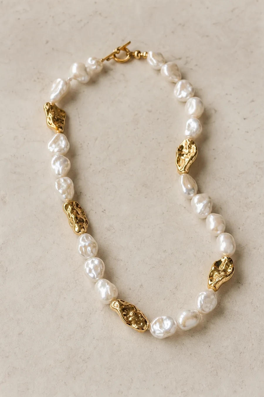 Baroque pearl necklace with uneven shapes and raw metal accents.